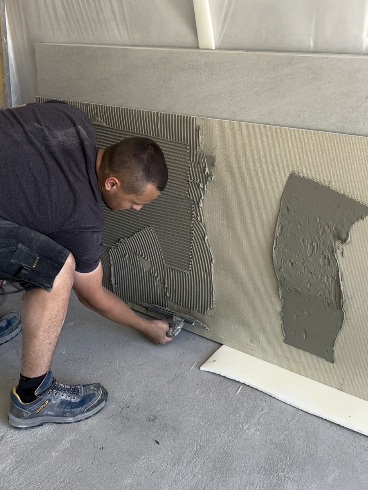 Sur les grands formats, le double encollage permet d’améliorer le transfert de colle et de limiter les zones creuses Double encollage pour la pose de carrelage grand format