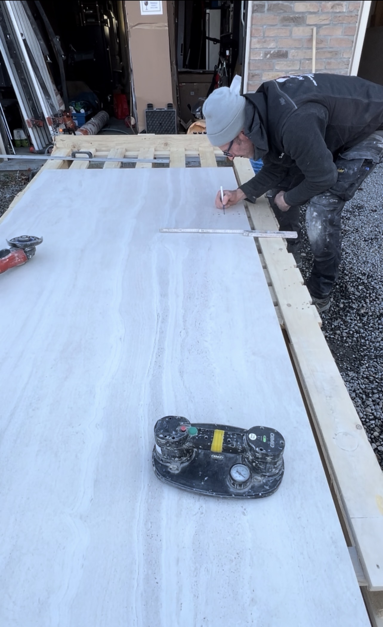 Avec le carrelage XXL, une prise de mesure et un traçage précis sont indispensables avant chaque découpe.  traçage sur plaque de carrelage grand format avant découpe